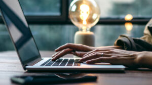 Hands blogging on a laptop